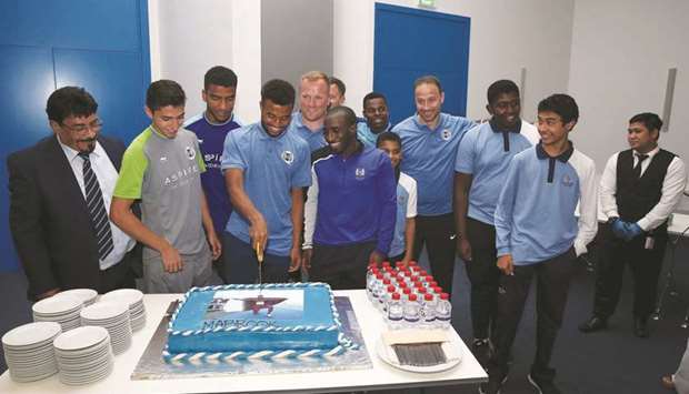 Owaab Barrow (fourth from left) cuts a cake during an Aspire Academy event celebrating his success at the recent Youth Olympic Games.