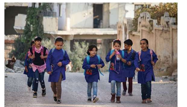 Syrian students walk on their way to school in an opposition-held neighbourhood of the southern city of Daraa.