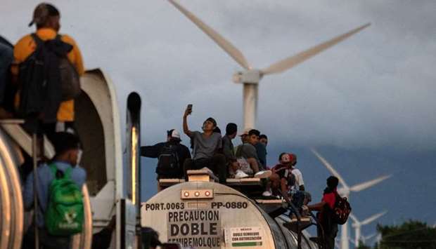 A truck carrying mostly Honduran migrants taking part in a caravan heading to the US, passes by a wind farm on their way from Santiago Niltepec to Juchitan, near the town of La Blanca in Oaxaca State, Mexico, yesterday.