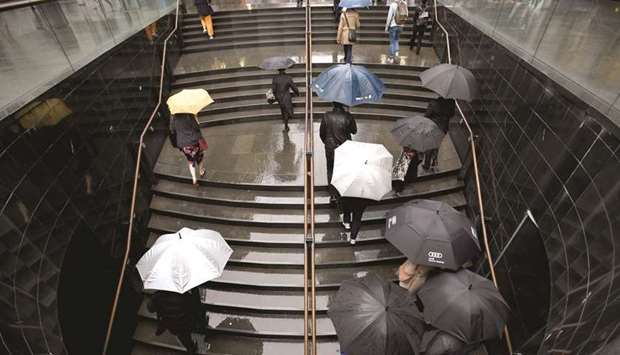 Office workers head to work as rains pelt Sydney.