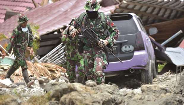 Indonesian troops patrol a devastated area at the Petobo sub-district in Palu, Indonesiau2019s Central Sulawesi.