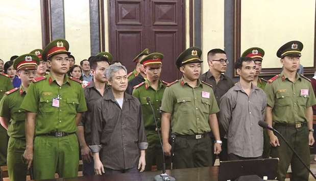 Luu Van Vinh, second left, and other activists who were charged of subversion, stand trial in Ho Chi Minh city yesterday.