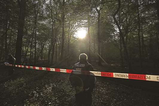 In this file photo taken on September 14, a police officer stands behind a barrier tape in the Hambach forest during an eviction of environmentalists living in tree houses.