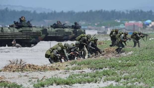 Philippine marines take position next to US marines Amphibious Assault Vehicles (AAV) during an amphibious landing exercise at the beach of the Philippine navy training center facing the South China Sea in San Antonio town, Zambales province, north of Manila.