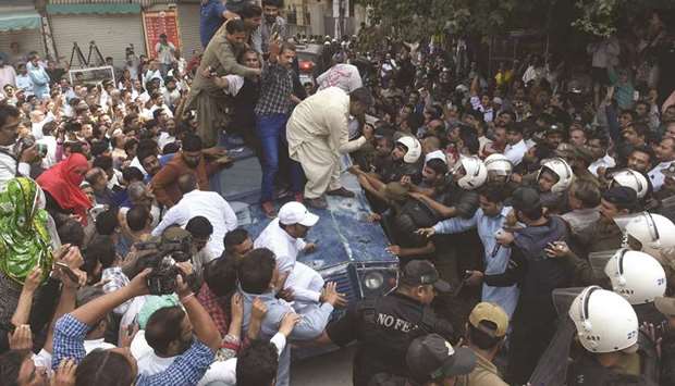 PML-N supporters try to prevent an armoured vehicle transporting Shehbaz Sharif at the corruption court in Lahore.
