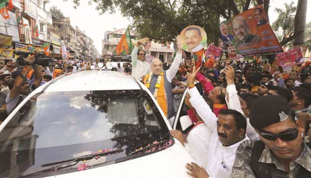 BJP chief Amit Shah and Madhya Pradesh Chief Minister Shivraj Singh Chouhan greet supporters in Indore, Madhya Pradesh yesterday.