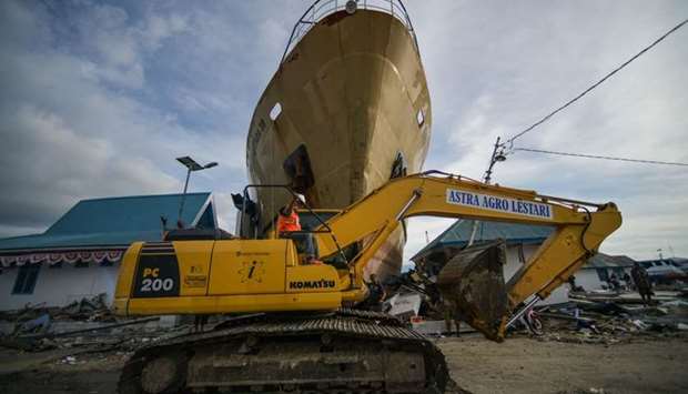 A heavy equipment crosses near a washed out passenger ferry in Wani, Indonesia's Central Sulawesi