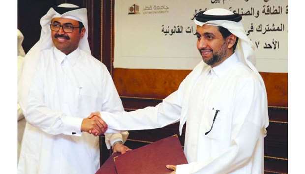 HE Al-Sada shaking hands with al-Derham after signing the MoU for co-operation between the Ministry of Energy and Industry and Qatar University.