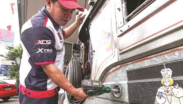 A gasoline attendant serves a customer yesterday amid warnings that oil companies will again hike oil prices this week.