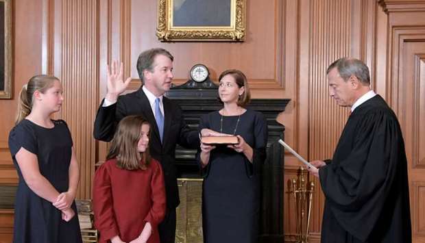Judge Brett Kavanaugh is sworn in as an Associate Justice of the US Supreme Court by Chief Justice John Roberts as Kavanaugh's wife Ashley holds the family bible and his daughters Liza and Margaret look on.