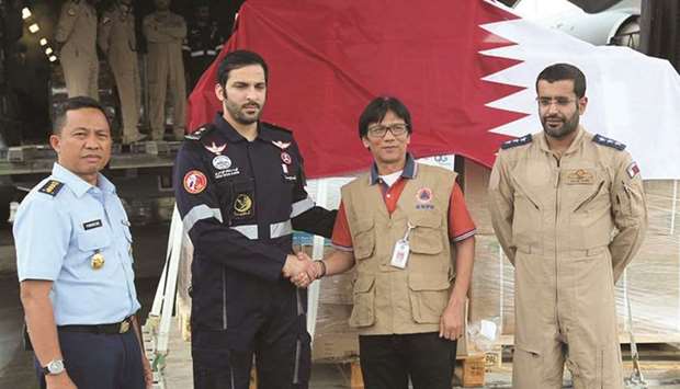 Qatari and BNPB officials shake hands after the handover of aid material.