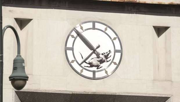 NEW WORK: A new street art work by Banksy, the anonymous British street artist, is of a rat in the inner portion of a clock above a closed former bank building on 14th Street and 6th Avenue in New York.
