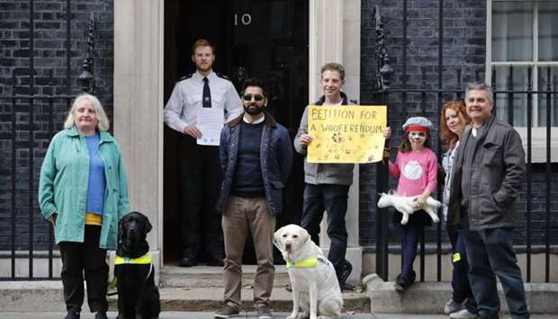 Campaigners with guide dogs pose outside number 10, Downing Street as they drop off a petition following a pro-EU, anti-Brexit march calling for a ,People's Vote on Brexit,, in central London.