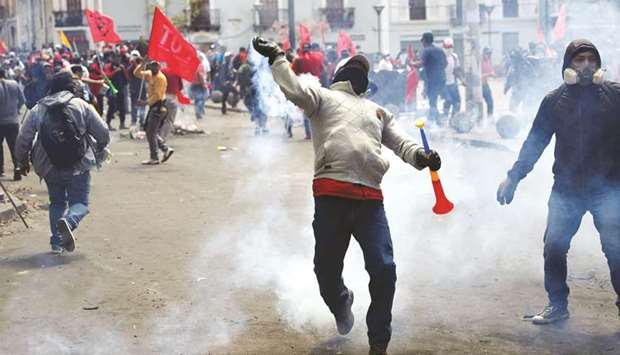 A demonstrator throws back a tear gas canister during a protest against Ecuadoru2019s President Lenin Morenou2019s austerity measures in Quito, Ecuador, yesterday.