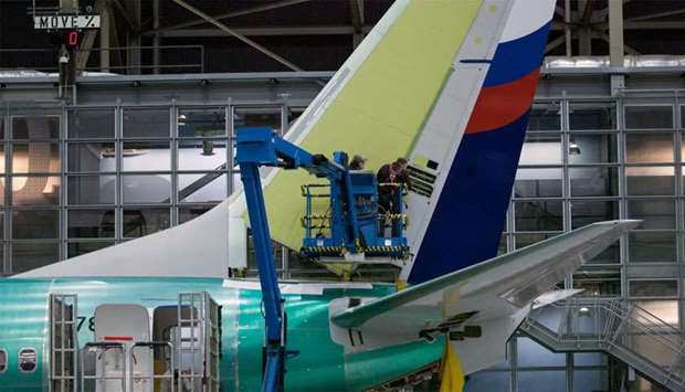 Boeing employees work on the tail of a Boeing 737 NG at the Boeing plant in Renton, Washington