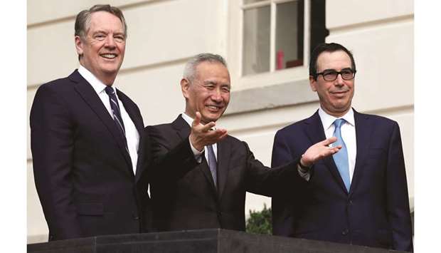 Chinau2019s Vice Premier Liu He gestures to the media between US Trade Representative Robert Lighthizer (left) and Treasury Secretary Steve Mnuchin before the two  countriesu2019 trade negotiations in Washington yesterday. The currency accord, which the US said had been agreed to earlier this year before trade talks broke down, would be part of what the White House considers to be a first-phase agreement with Beijing.