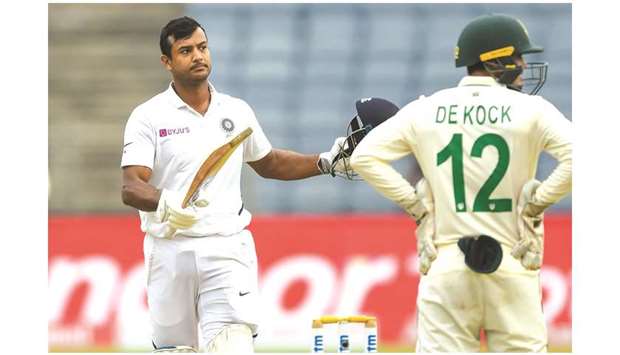 Indiau2019s Mayank Agarwal (left) celebrates after scoring a century on the first day of second Test against South Africa at the Maharashtra Cricket Association Stadium in Pune, India, yesterday. (AFP)