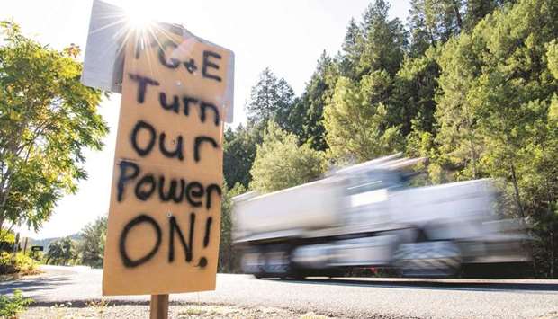 A sign calling for PG&E to turn the power back on is seen on the side of the road during a statewide blackout in Calistoga, California.