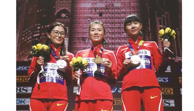 Gold medallist Hong Liu (centre) of China poses with compatriots and silver medallist Shenjie Qieyang and bronze medallist Lijuing Yang during the medal ceremony for the womenu2019s 20km race walk at Khalifa International Stadium yesterday. (Reuters)