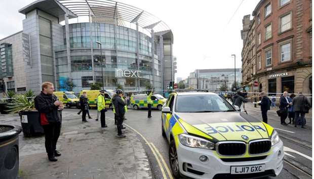 Police cars are seen outside the Arndale shopping centre after several people were stabbed in Manchester, Britain