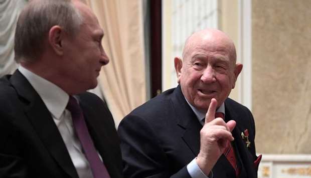 In this file photo taken on April 11, 2017 Russian President Vladimir Putin (L) speaks with cosmonautics veteran Alexei Leonov during a screening of the film ,The Spacewalker, in Moscow