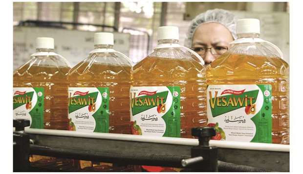 A worker watches as bottles of palm cooking oil roll out of the production line at a factory, in Ipoh,  Malaysia. In the first nine months of 2019, India was the biggest buyer of Malaysian palm oil, taking 3.9mn tonnes, according to data compiled by the Malaysian Palm Oil Board.