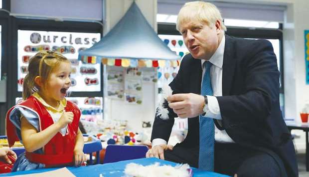 Prime Minister Boris Johnson gestures as he participates in an art class with four year-old Scarlet Fickling at St Maryu2019s and All Saints Primary School in Beaconsfield, Buckinghamshire, yesterday.