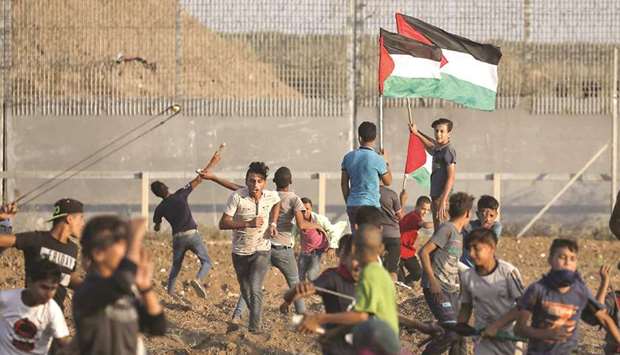 Palestinian protesters take part in a demonstration by the border fence between the Gaza Strip and Israel, east of Gaza City, yesterday.