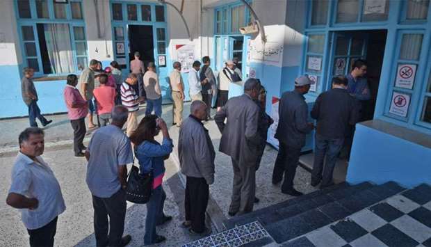 Tunisian voters queue outside a polling station in the capital Tunis during the second round of the presidential election.