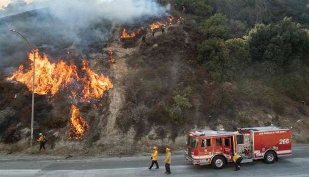 Firefighters check on a backfire during the Saddleridge fire in Newhall, California