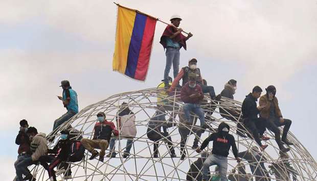 Demonstrators sit atop the sculpture Esfera de Movimientos Oscilantes (Sphere of Oscillating Movements) at Quitou2019s El Arbolito park during the 10th day of a protest over a fuel price hike ordered by the government to secure an IMF loan, near the National Assembly.