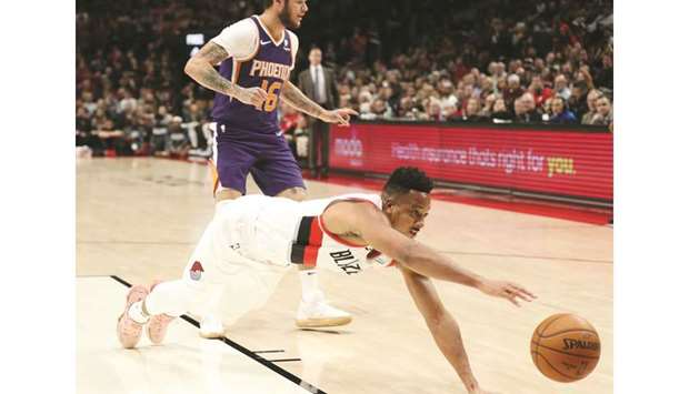Portland Trail Blazers guard CJ McCollum (foreground) dives for a loose ball against the Phoenix Suns in the first half at Moda Center in Portland, United States, on Saturday. (USA TODAY Sports)