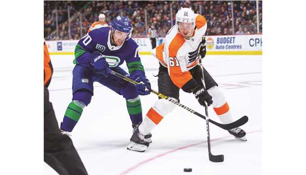 Vancouver Canucks left wing Tanner Pearson (left) and Philadelphia Flyers defenseman Justin Braun battle for the puck during the NHL game in Vancouver, Canada, on Saturday. (USA TODAY Sports)