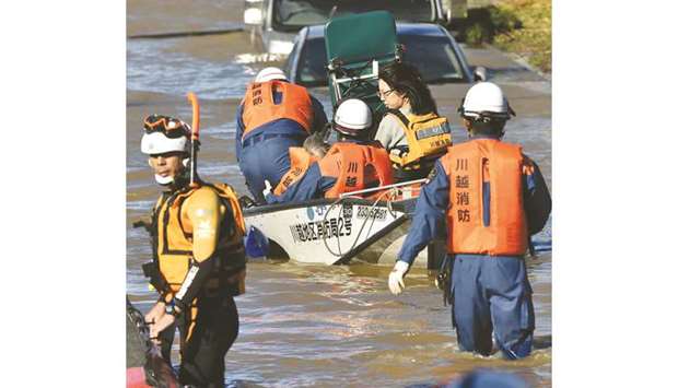 Rescue personnel use a boat to evacuate people and caregivers from the Kawagoe Kings Garden elderly care centre in Kawagoe city, Saitama prefecture.