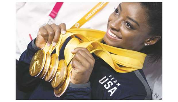 USAu2019s Simone Biles poses after the apparatus finals with the five gold medals she won at the FIG Artistic Gymnastics World Championships at the Hanns-Martin-Schleyer-Halle in Stuttgart, southern Germany, yesterday. (AFP)