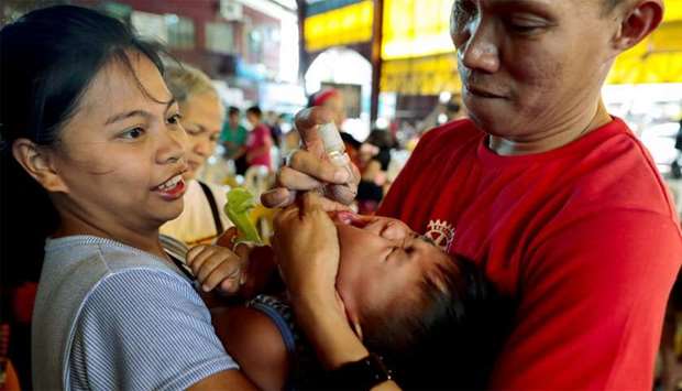 A health worker administers free polio vaccine to a child during a government-led mass vaccination program in Quezon City