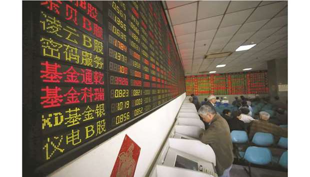 Investors look at computer screens showing stock information at a brokerage house in Shanghai. The Composite closed up 1.2% to 3,007.88 points yesterday.