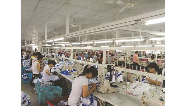 Workers make Orolay jackets at the companyu2019s factory complex in Jiaxing, Zhejiang province. Chinau2019s exports in September fell 3.2% from a year earlier, the biggest fall since February, customs data showed yesterday.