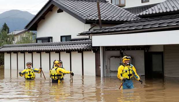 Police search a flooded area in the aftermath of Typhoon Hagibis, which caused severe floods at the Chikuma River in Nagano Prefecture, Japan
