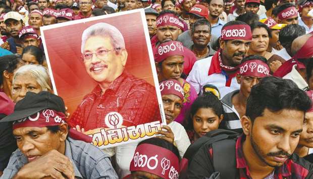 Supporters carry placards showing Sri Lankau2019s former defence secretary and presidential candidate, Gotabhaya Rajapaksa, as they gather for the presidential election rally in Kadawatha.