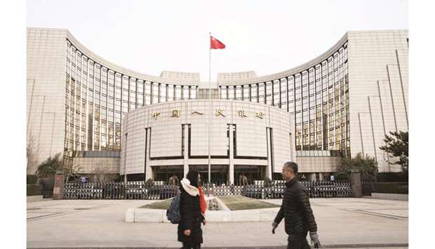 Pedestrians walk past the Peopleu2019s Bank of China headquarters in Beijing. As  Facebook readies to launch its answer to bitcoin, China is set to introduce its own digital currency u2013 one that could allow the government and the central bank to see what people spend their money on, according to analysts.