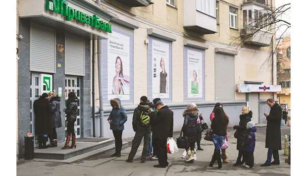 Customers queue to withdraw hyrvnia currency from an ATM outside a Privatbank branch in Kiev. PrivatBanku2019s lawsuit against the former owners alleges fraud that it says cost the bank hundreds of millions of dollars.