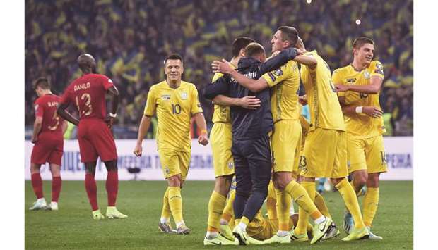 Ukraineu2019s players celebrate after the Euro 2020 qualification win over Portugal at the NSK Olimpiyskyi stadium in Kyiv on Monday. (AFP)