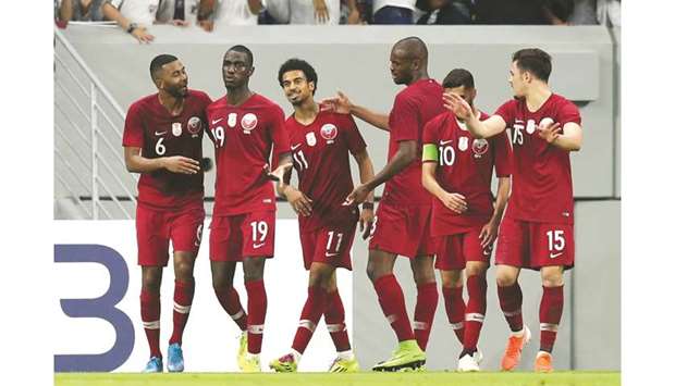 Qataru2019s Almoez Ali (second left) celebrates with teammates after scoring against Oman during the FIFA World Cup Qatar 2022 and AFC Asian Cup China 2023 qualifiers at the Al Janoub Stadium yesterday. (Reuters)