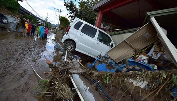 A car sits next to a badly damaged home in Nagano after Typhoon Hagibis hit Japan