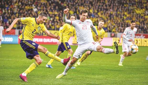 Swedenu2019s Mikael Lustig shoots past Spainu2019s Mikel Oyarzabal during the Euro 2020 Group F qualifying match in Stockholm, Sweden on Tuesday night. (Reuters)