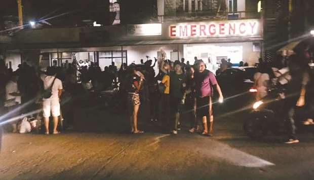 People are seen receiving assistance outside Kidapawan Doctors Hospital in Kidapawan City, after an earthquake.