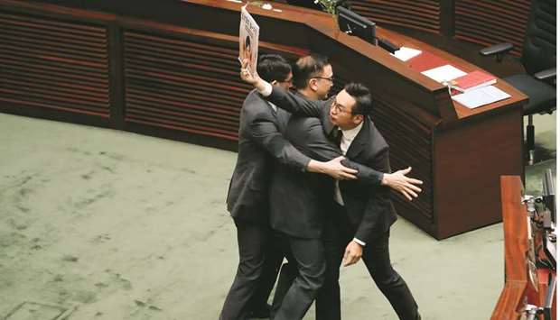 Security personnel block a lawmaker waving a placard at Hong Kongu2019s Chief Executive Carrie Lam during a Legislative Council meeting regarding her policy address, in Hong Kong yesterday.