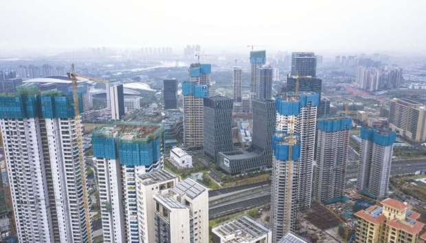 Construction cranes operate at residential and office building construction sites in this aerial photograph taken in the  Wuxiang New District of Nanning, Guangxi province. Property investment in China in September grew 10.5% from year earlier, unchanged from the pace of growth in August, according to National Bureau of Statistics data yesterday.