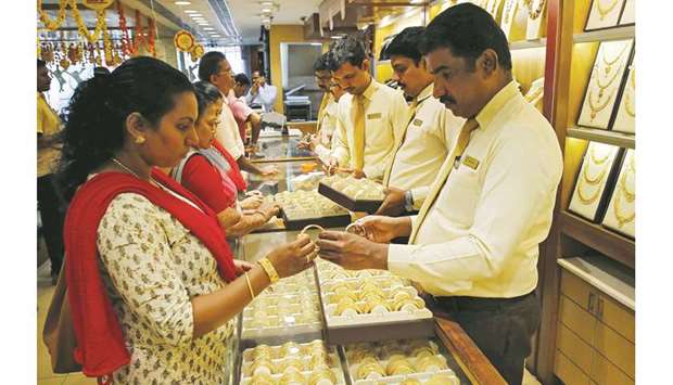 A salesman shows gold bangles to a customer inside a jewellery showroom in Kochi. Gold futures in India were trading around Rs38,050 per 10 grams yesterday, having hit a record high 39,885 rupees last month. Prices are up more than 21% so far in 2019.